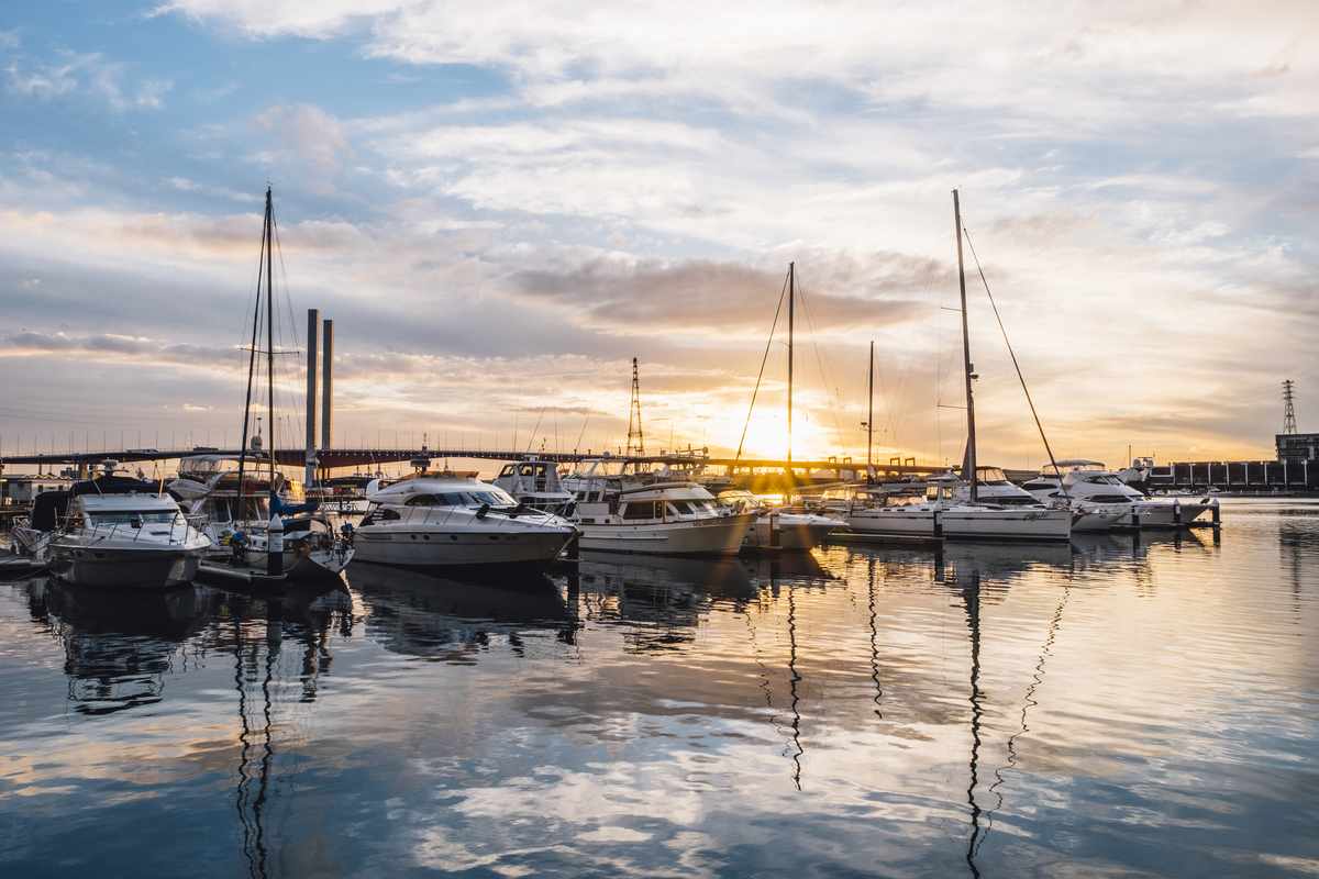 Yacht reflected in the harbour water in the evening